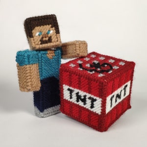 Könnte beinhalten: Eine braune und blaue Minecraft-Figur hält einen roten und weißen TNT-Block mit dem Wort "TNT" darauf.