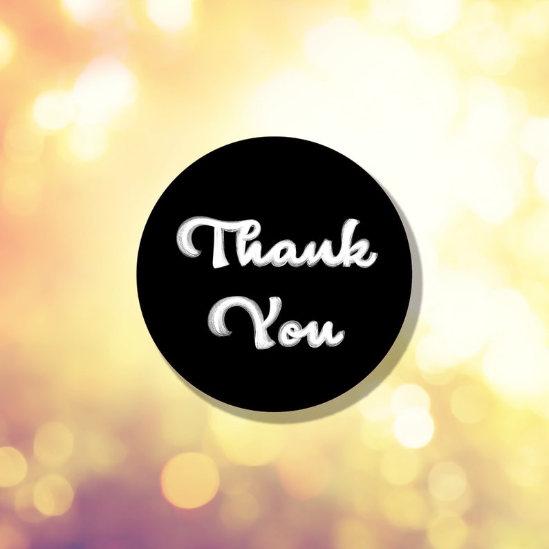 May include: A black circle with white text that says "Thank You" against a blurred background of yellow and orange bokeh lights.