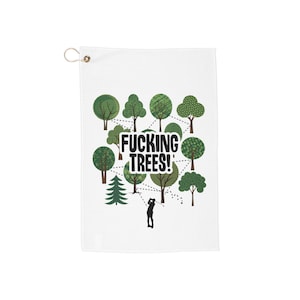 Puede incluir: Toalla de golf blanca con un diseño humorístico. La toalla presenta una colección de árboles verdes y una silueta de golfista. El texto en negrita dice "FUCKING TREES!" encima del golfista. Hay una arandela dorada en la parte superior para colgar.