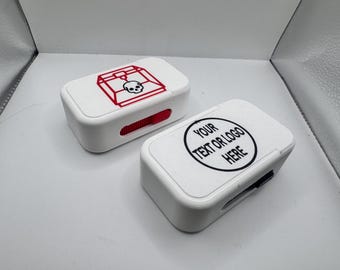 May include: Two white rectangular boxes. One has a red skull and cage design. The other has a black circle with the text "YOUR TEXT OR LOGO HERE". Both have a red slider on the side.