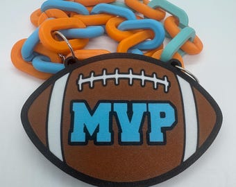 May include: A brown football with a white stripe and the word "MVP" in blue letters. The football is attached to a chain made of orange, blue, and green links.