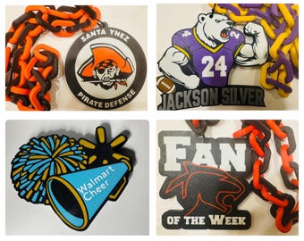 May include: Four different car air fresheners with black and orange chain links. The first air freshener is round and white with black text that says "Santa Ynez Pirate Defense". The second air freshener is purple and white with black text that says "Jackson Silver" and a football. The third air freshener is blue and yellow with black text that says "Walmart Cheer". The fourth air freshener is black with white text that says "Fan of the Week".