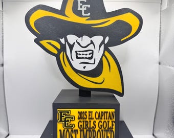 May include: A black and yellow trophy featuring a cowboy graphic. The trophy reads "2025 EL CAPITAN GIRLS GOLF MOST IMPROVED" and "DELILAH FRANK". The cowboy graphic is wearing a yellow hat with the letters "EC".