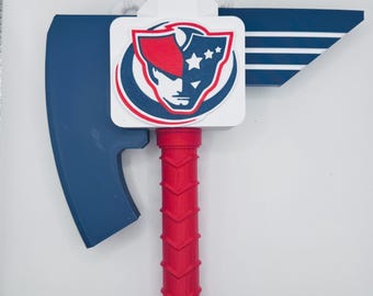 May include: A red, white, and blue axe with a shield emblem. The axe head is blue, and the handle is red with a textured design. The emblem features a face and stars.