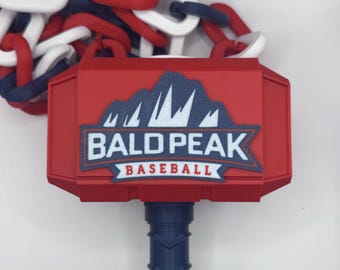 May include: A red and blue baseball-themed hammer with the text "BALD PEAK BASEBALL". The hammer has a blue handle and a red head with a mountain graphic. A chain of red, white, and blue links is visible.