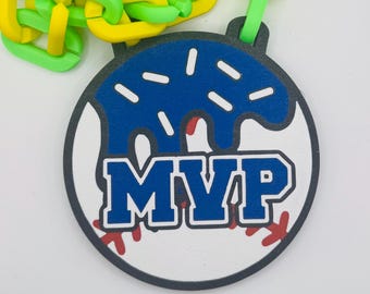 May include: A baseball-themed medal with a blue and white design, featuring the text "MVP". The medal has a blue glaze and is attached to a chain of yellow and green links. Red baseball stitching is visible.