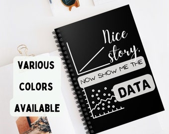 Puede incluir: Cuaderno negro de espiral con texto blanco que dice "Nice story. Now show me the data." El texto está acompañado de un gráfico de líneas con puntos de datos y un rectángulo blanco con la palabra "DATA" dentro.