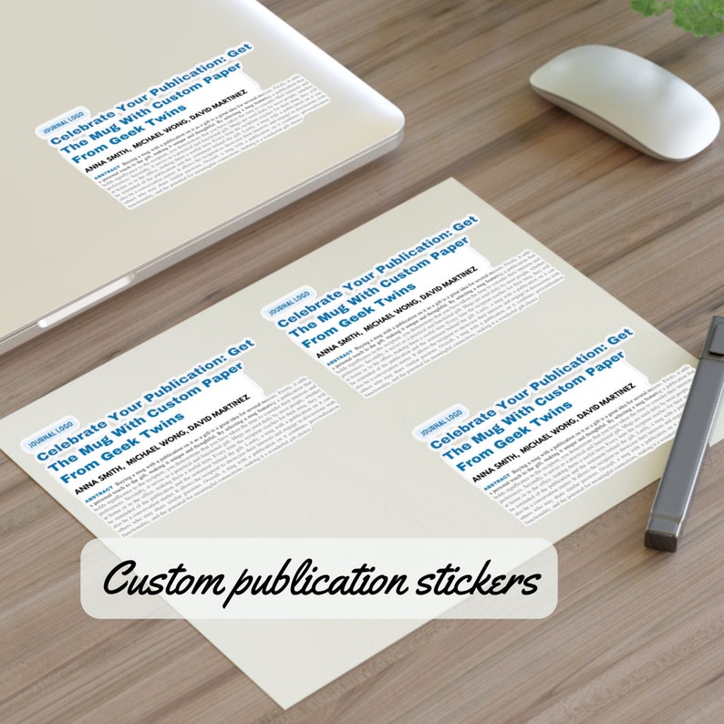 Op de afbeelding: Drie witte stickers met de tekst "Celebrate Your Publication: Get The Mug With Custom Paper From Geek Twins" en de namen "Anna Smith, Michael Wong, David Martinez". De stickers bevinden zich op een houten oppervlak. Gepersonaliseerde publicatiestickers.