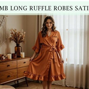 Pode incluir: Robe de cetim cor ferrugem com acabamento em babados e cinto a condizer. O robe tem um design envolvente e apresenta o texto "EMB LONG RUFFLE ROBES SATIN" na parte superior da imagem. O robe &eacute; na altura do joelho e tem um ajuste folgado.
