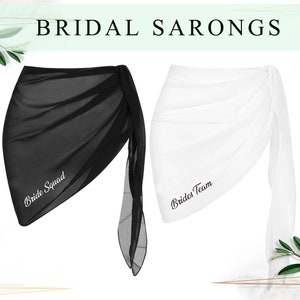 May include: Two sheer sarongs, one black and one white, with the text "Bride Squad" and "Brides Team" embroidered on them.
