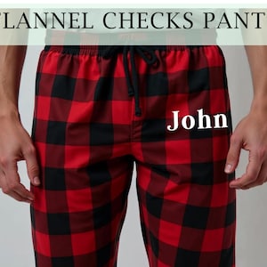 May include: Red and black plaid flannel pajama pants with the name "John" embroidered on the front.