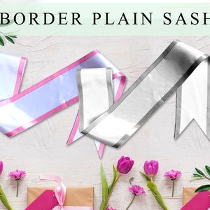 Può includere: Due fasce di raso bianco con bordi a contrasto. Una fascia ha un bordo rosa e l'altra un bordo argentato. Le fasce sono esposte su una superficie di legno bianco con fiori rosa.