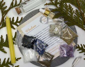 May include: A kit for a wisdom spell with a variety of ingredients including herbs, crystals, and a small glass bottle. The kit is on a gray wooden surface with the words "Wisdom" and "Row Riv" written on a card.