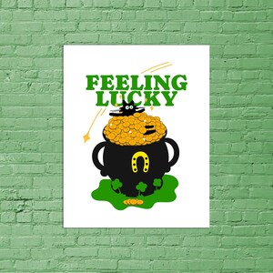 May include: A black cat sits on top of a pot of gold coins with a horseshoe on the side. The text "Feeling Lucky" is above the pot.