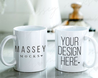 Puede incluir: Dos tazas de cerámica blanca, una con el texto "MASSEY MOCKS" y la otra con el texto "YOUR DESIGN HERE".