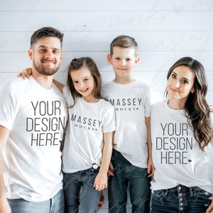 May include: A family of four wearing white t-shirts with the text "Your Design Here" and "Massey Mocks" printed on them. The family is standing in front of a white wood panel background.