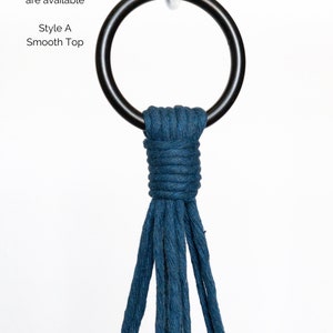 May include: A dark blue macrame plant hanger with a smooth top design. The hanger is suspended from a black metal ring. Text in the image reads "2 Style Options are available" and "Style A Smooth Top".
