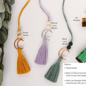 Decor piece to hang from the rearview mirror of your car.  Features a metal crescent moon with colorful brushed macrame cord tassel.  A small dropper bottle of essential oils in the corner.