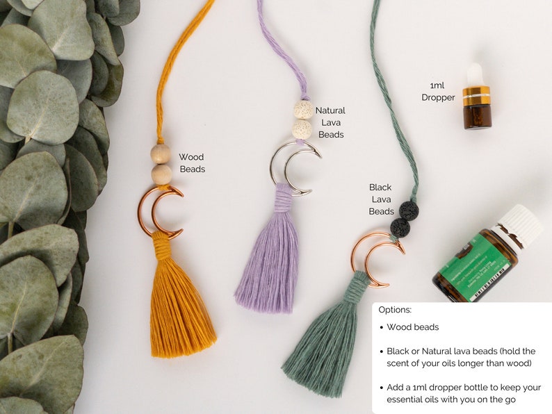 Decor piece to hang from the rearview mirror of your car.  Features a metal crescent moon with colorful brushed macrame cord tassel.  A small dropper bottle of essential oils in the corner.