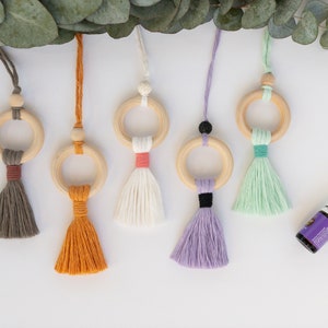 May include: Six wooden ring car air fresheners with colorful tassels. The rings are made of natural wood and the tassels are made of cotton yarn. The colors of the tassels are gray, orange, white, lavender, and green.