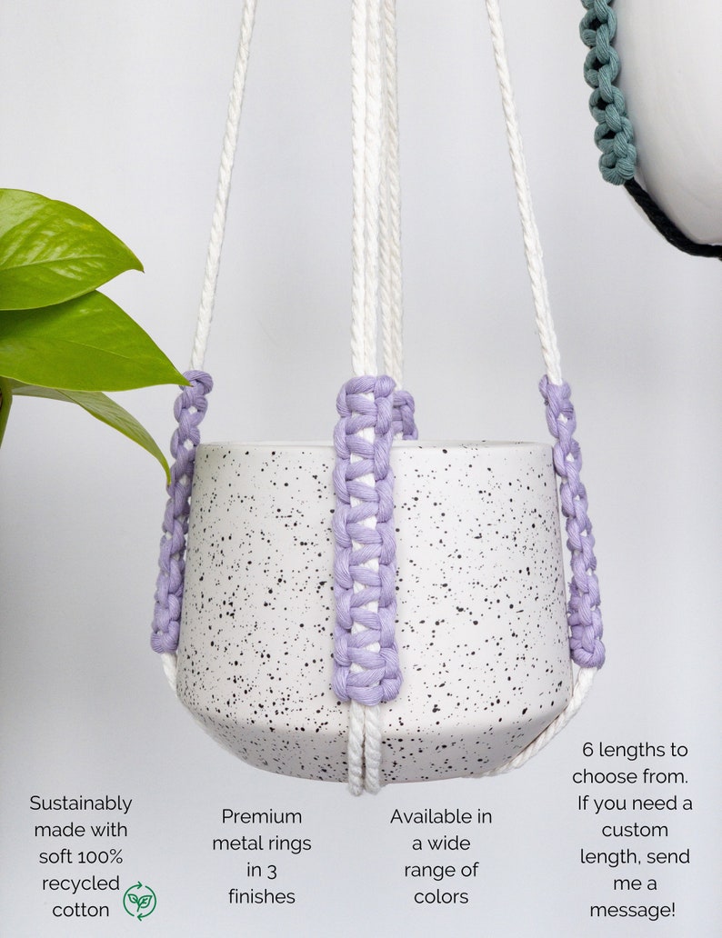 Op de afbeelding: Een witte gespikkelde keramische plantenpot in een macram&eacute; hanger van wit katoenen koord met lavendelkleurige gevlochten accenten. De tekst op de afbeelding luidt: "Sustainably made with soft 100% recycled cotton", "Premium metal rings in 3 finishes", "Available in a wide range of colors" en "6 lengths to choose from. If you need a custom length, send me a message!"