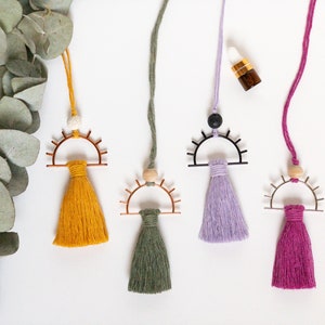 May include: Four colorful tassel car air fresheners with different colored tassels and metal eye designs. The tassels are yellow, green, purple, and pink.