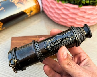 May include: A brass telescope with a black finish and a gold inscription that reads "Dollond London".