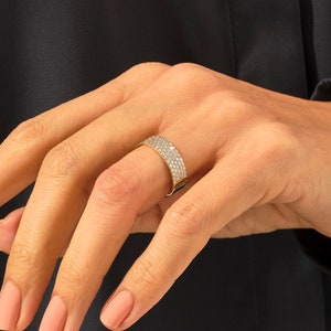May include: A gold band ring with a row of small diamonds set in a pave setting.