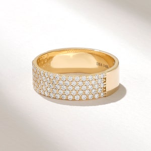 May include: A gold band ring with a row of small diamonds set into the band. The ring is marked "DIA 14K" on the inside.