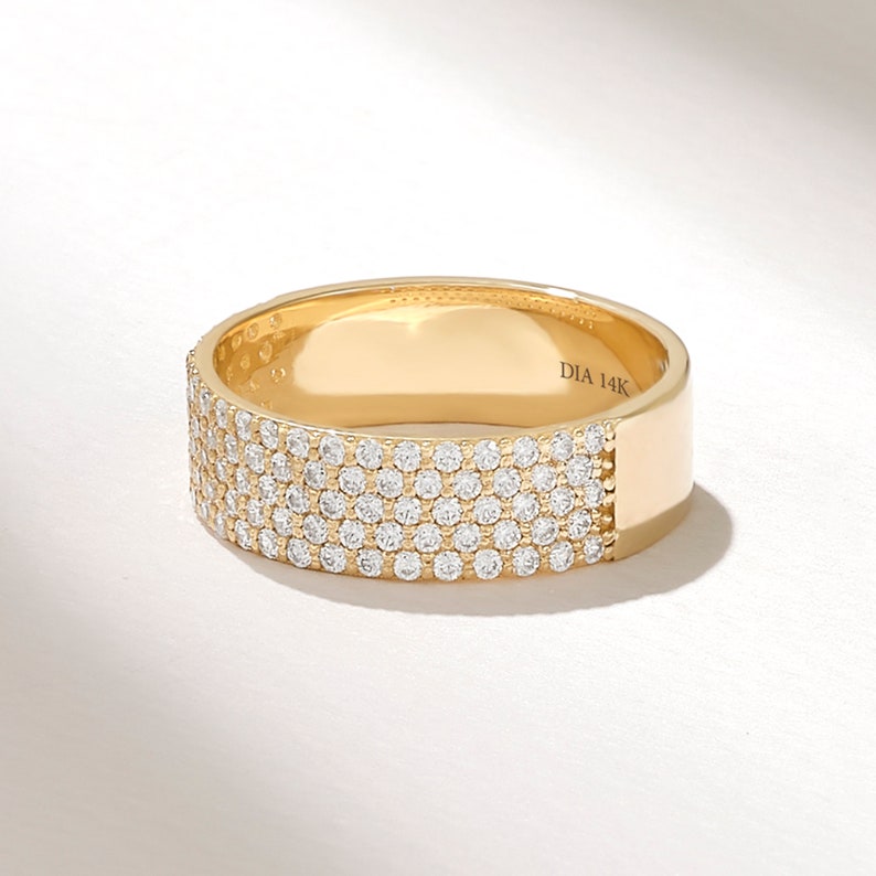May include: A gold band ring with a row of small diamonds set into the band. The ring is marked "DIA 14K" on the inside.