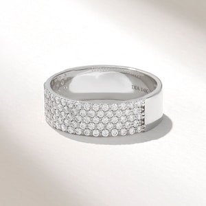 May include: A white gold band ring with five rows of pave set diamonds. The ring is marked "DIA 14K" on the inside.