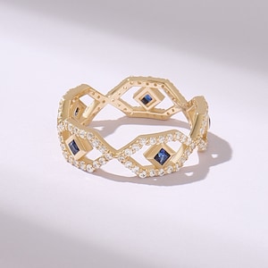 Geometric Art Deco sapphire and lab diamond ring in solid yellow gold with pavé diamonds and princess cut blue sapphires on an open band design