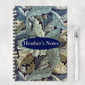 May include: A spiral bound notebook with a dark blue background and a floral pattern in shades of green, blue, and yellow. The notebook has a navy blue oval label that says "Heather's Notes".