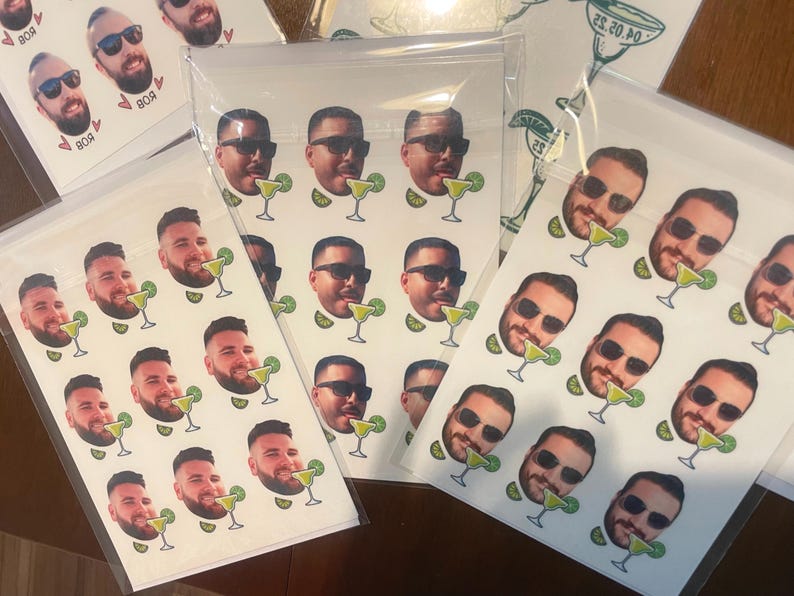 May include: A sheet of white stickers with multiple images of people's faces with a margarita glass in front of them. The stickers are printed with a white background and the images are in color.