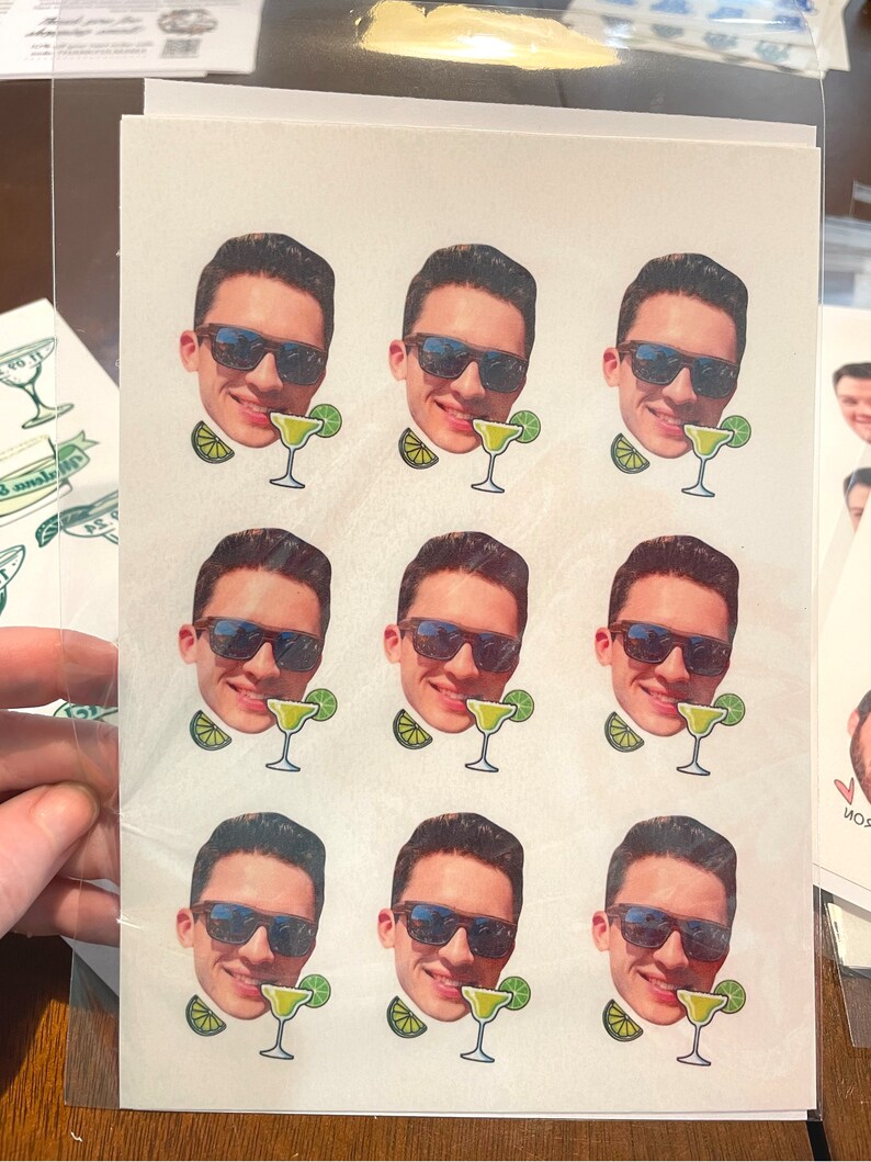 May include: Nine white stickers with a man's face wearing sunglasses and a margarita glass. Each sticker has a lime wedge next to the glass.