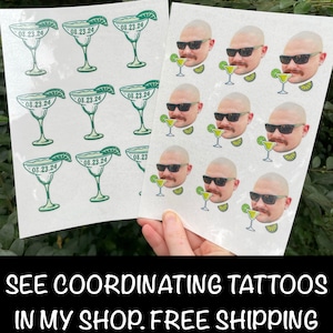 May include: Two sheets of stickers. One sheet has nine green margarita glass stickers with the date "08.23.24" printed on each. The other sheet has nine stickers of a man's face with sunglasses and a margarita glass. The text "SEE COORDINATING TATTOOS IN MY SHOP. FREE SHIPPING ON ORDERS OVER $35" is printed at the bottom of the image.