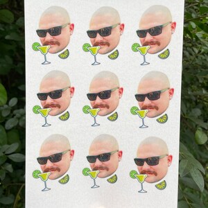 May include: Nine white stickers with a cartoon image of a man wearing sunglasses and a mustache. Each sticker has a margarita glass with a lime wedge and a lime slice.
