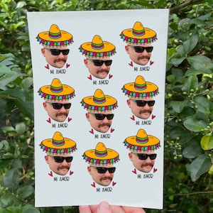 May include: A sheet of nine colorful stickers featuring a cartoon face wearing a sombrero and sunglasses. Each sticker has the text "MI AMOR" printed below the image.