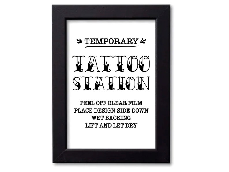 Puede incluir: Un letrero en blanco y negro en un marco negro que dice "TEMPORARY TATTOO STATION" con las siguientes instrucciones: "PEEL OFF CLEAR FILM PLACE DESIGN SIDE DOWN WET BACKING LIFT AND LET DRY"