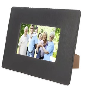 Op de afbeelding: Een zwart leisteen fotolijst met een houten standaard. De lijst bevat een foto van een gezin van vijf personen die in een park lachen.