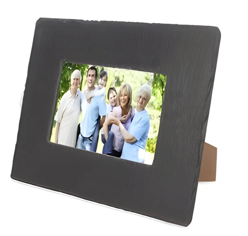 Op de afbeelding: Een zwart leisteen fotolijst met een houten standaard. De lijst bevat een foto van een gezin van vijf personen die in een park lachen.