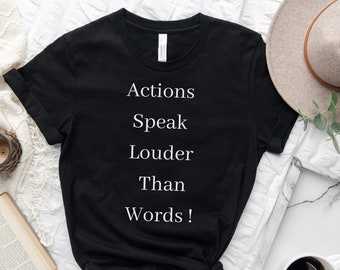Pode incluir: Camiseta preta com texto branco que diz "Actions Speak Louder Than Words!"