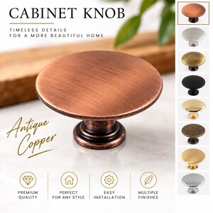 Pode incluir: Um puxador de armário redondo com acabamento em cobre antigo, apresentando um topo circular plano e uma base cónica. A imagem exibe o texto CABINET KNOB, Antique Copper e ícones para qualidade premium, estilo e acabamentos múltiplos.