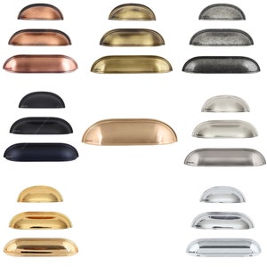 May include: A set of 10 cabinet pulls in various finishes, including brass, nickel, and black. The pulls are all the same size and shape, with a rounded top and a flat bottom.