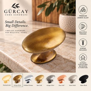 May include: An oval-shaped cabinet knob with an antique brass finish. The hardware features a smooth, rounded top surface and a tapered base. Text on the image includes GÜRCAY HOME HARDWARE, Small Details. Big Difference., and various finish labels.