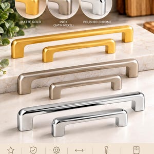 May include: A collection of six metal cabinet pulls in three finishes: matte gold, inox satin nickel, and polished chrome. Each finish is shown in two sizes, 128 mm and 192 mm. The pulls feature a rectangular bar design with rounded edges.