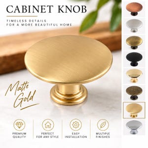 May include: A matte gold cabinet knob with a circular, flat top and a cylindrical base. The image includes text reading CABINET KNOB, TIMELESS DETAILS FOR A MORE BEAUTIFUL HOME, Matte Gold, PREMIUM QUALITY, PERFECT FOR ANY STYLE, EASY INSTALLATION, and MULTIPLE FINISHES.