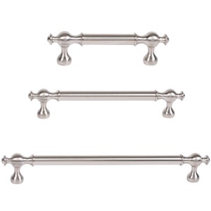 Puede incluir: Tres tiradores de armario plateados con extremos redondeados y una barra central. Los tiradores están etiquetados con "Gurray".