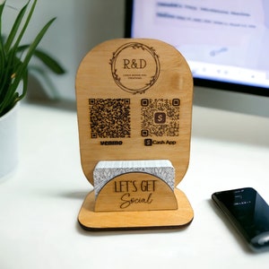 May include: A wooden business card holder with the text "R&D Laser Design and Creations" and QR codes for Venmo and Cash App. The holder also has the text "Let's Get Social" and holds a stack of cards.