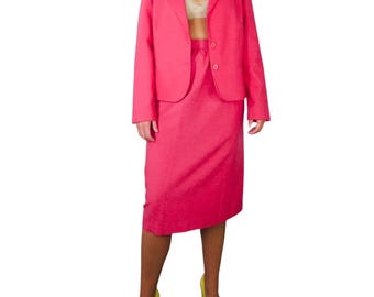May include: A hot pink blazer and skirt suit. The blazer has a notched collar, long sleeves, and two button closures. The skirt is knee-length and has a straight silhouette.